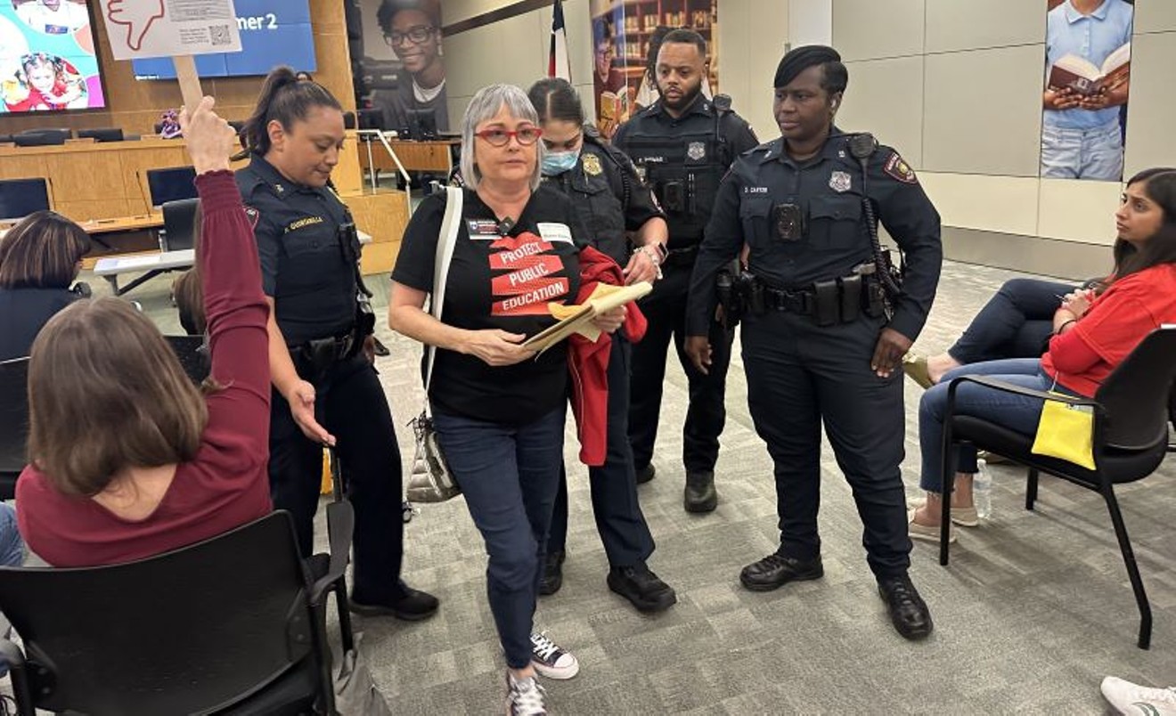 A cadre of HISD officers ushered Susan Espinoza out of Thursday's board meeting.