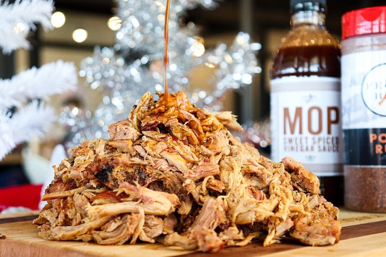 A whole heap of hog gets a kiss of sauce. - PHOTO BY ABBIE ARNOLD